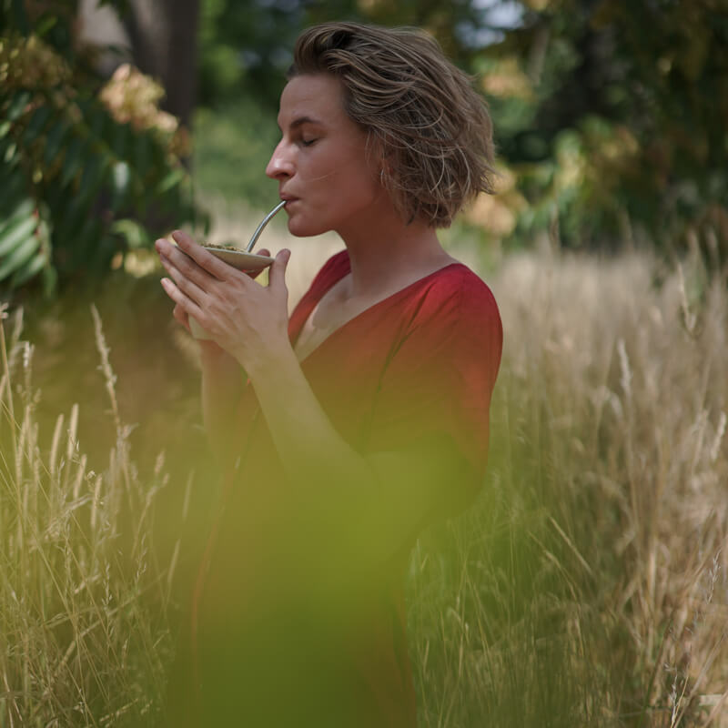 Frau trinkt caámate mate tee in der cuia im Feld